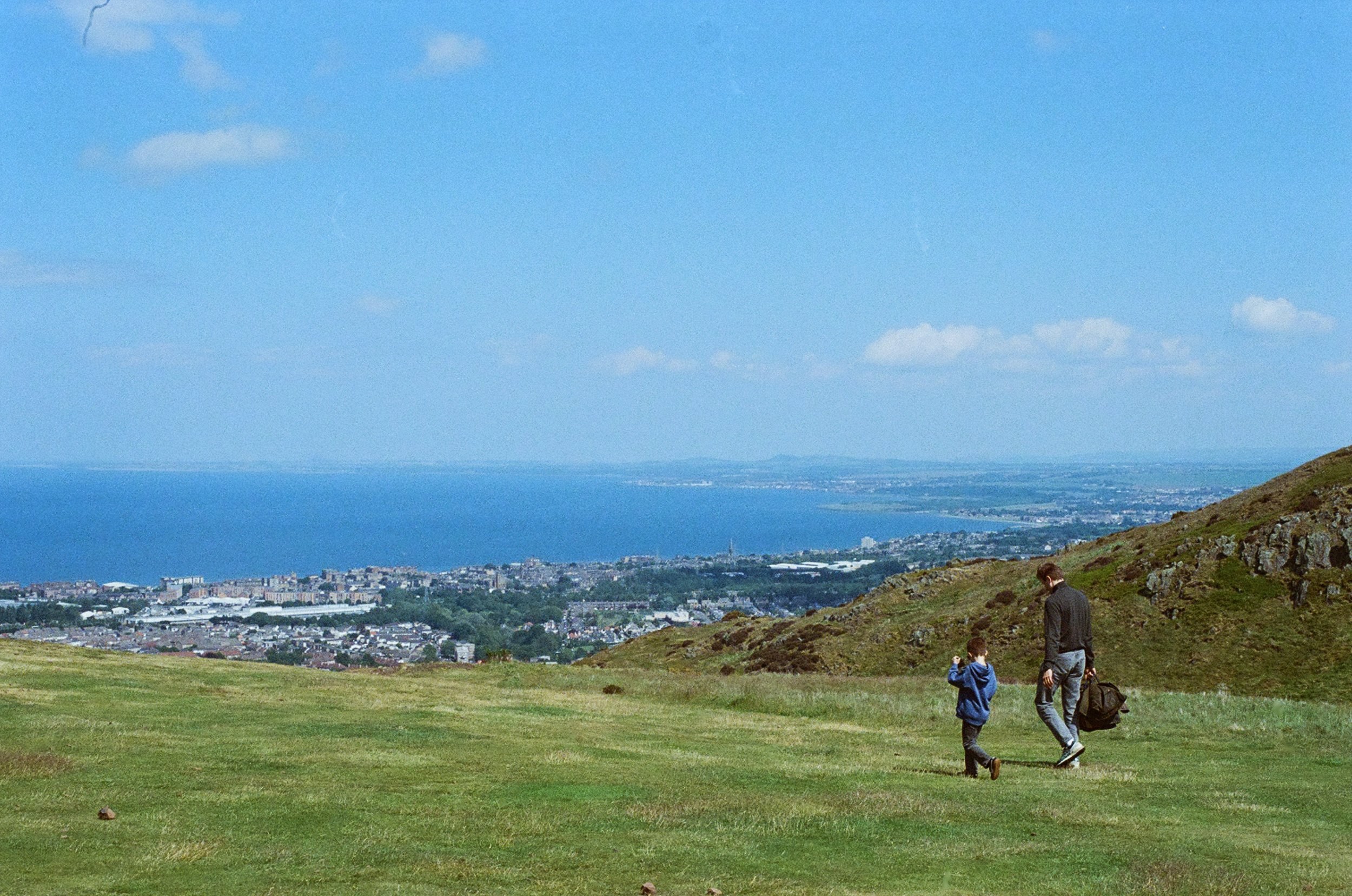 Father and son walking by Arthur's Seat in summer on film