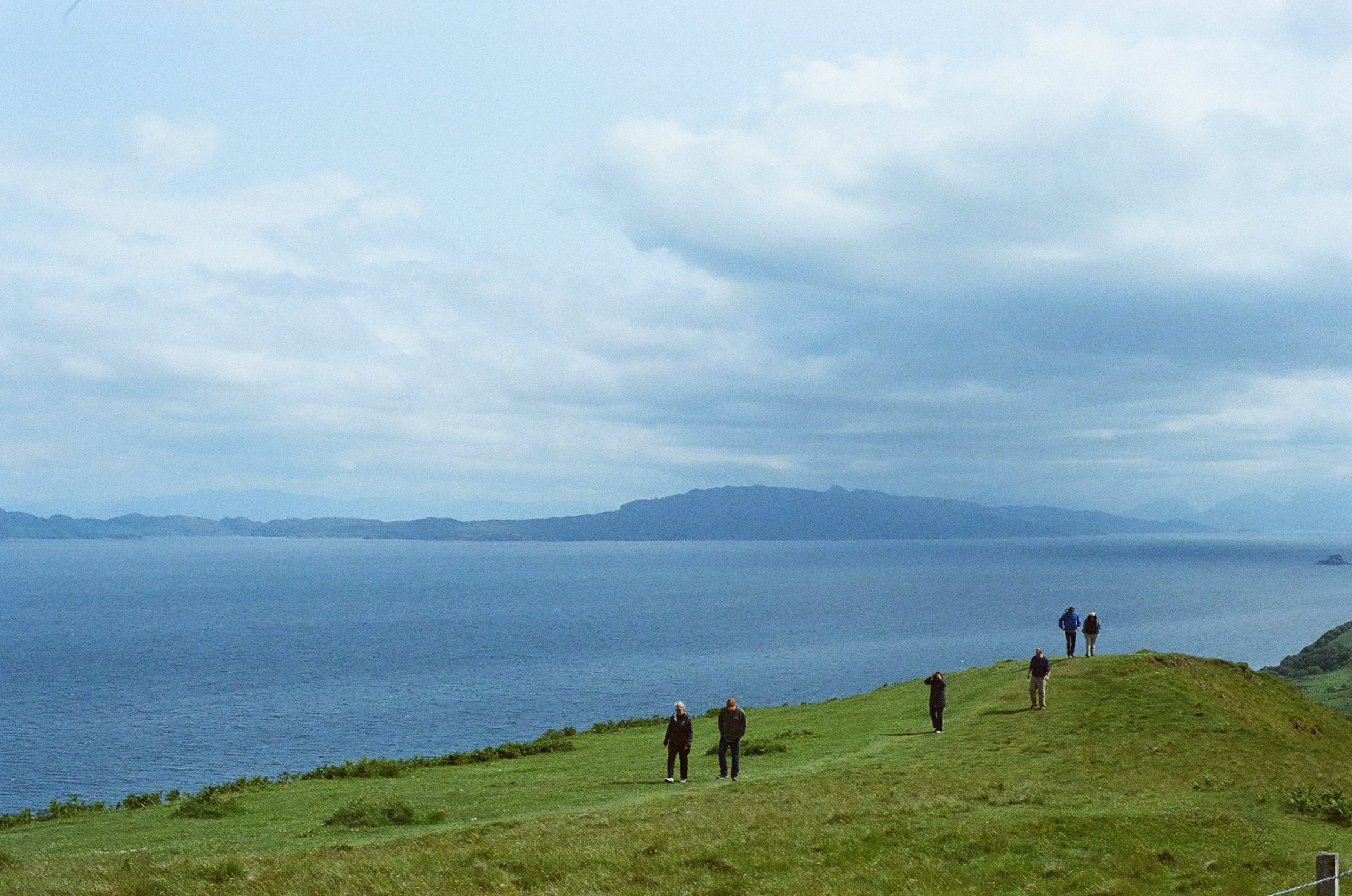 Family walking by coast in summer in Skye on film by Arsalan Kamal